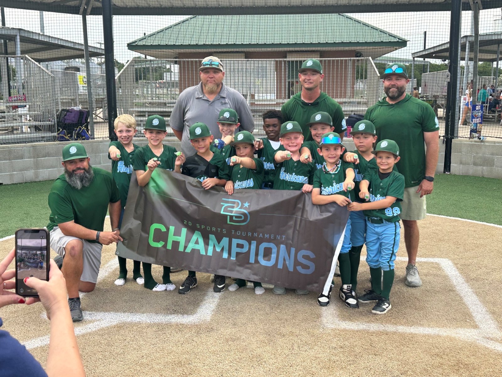 Hurricanes team and coaches with a Champions banner