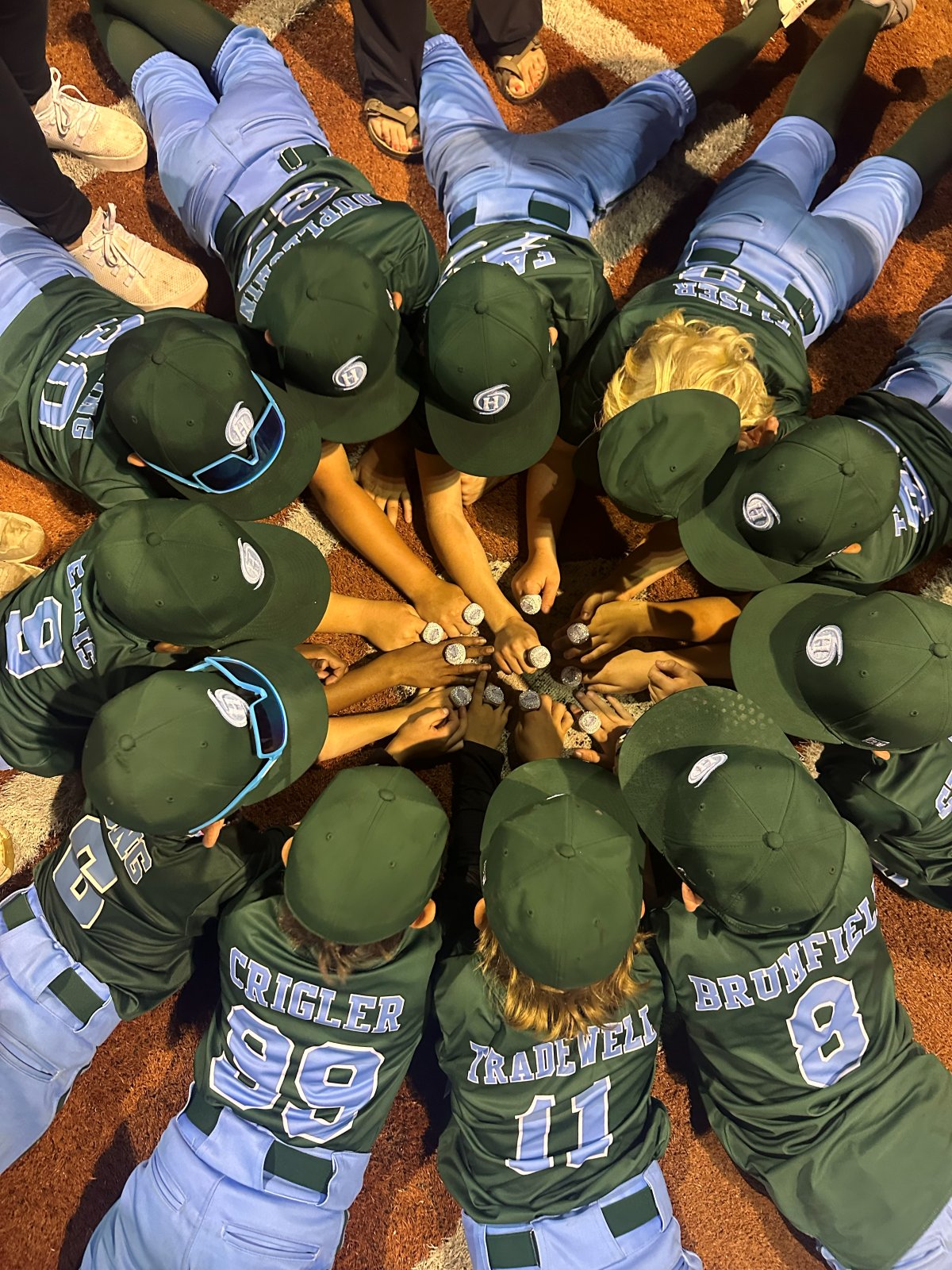 Players huddled with hands in, wearing rings