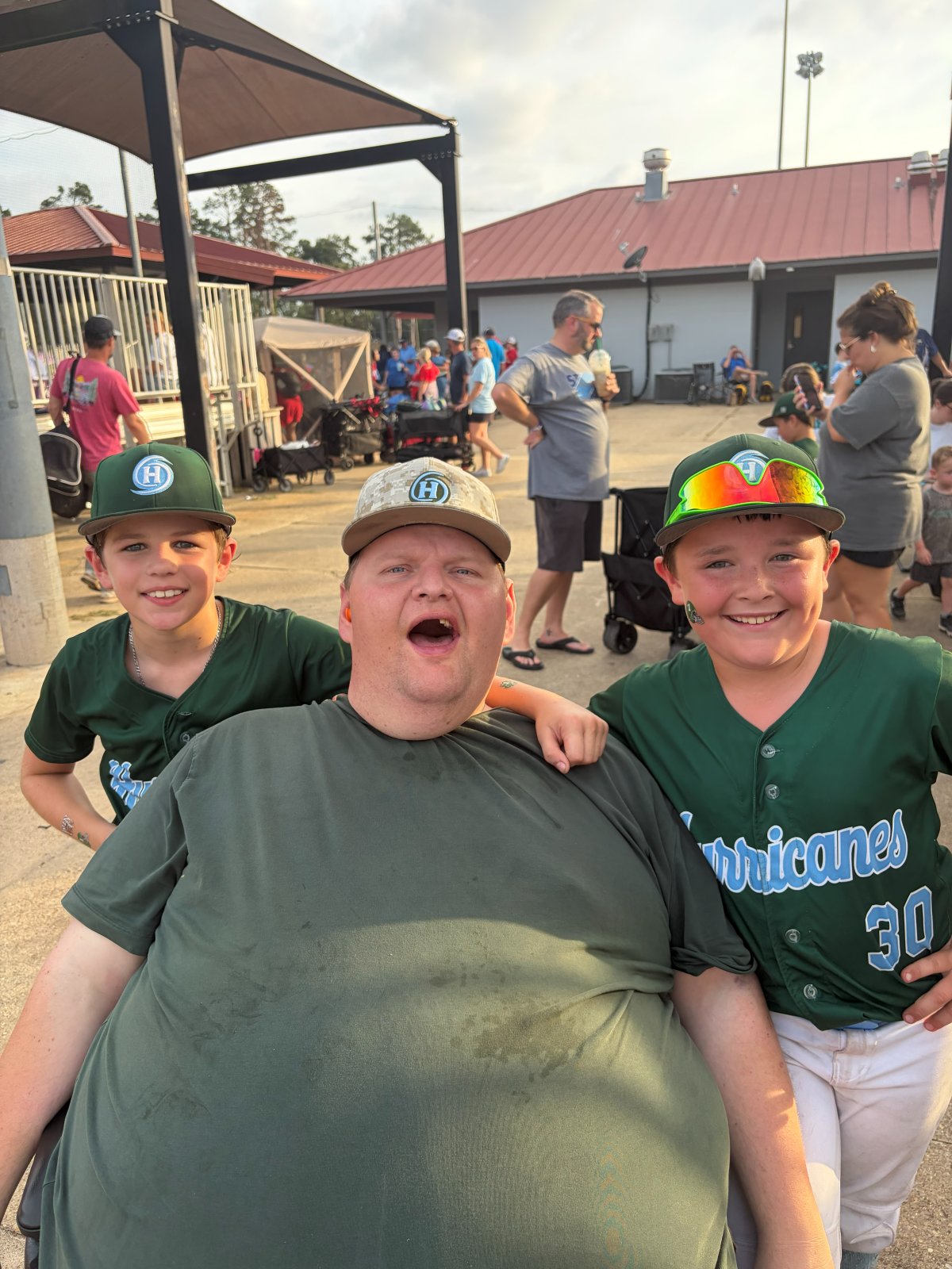 Patrick smiling with two Hurricanes players
