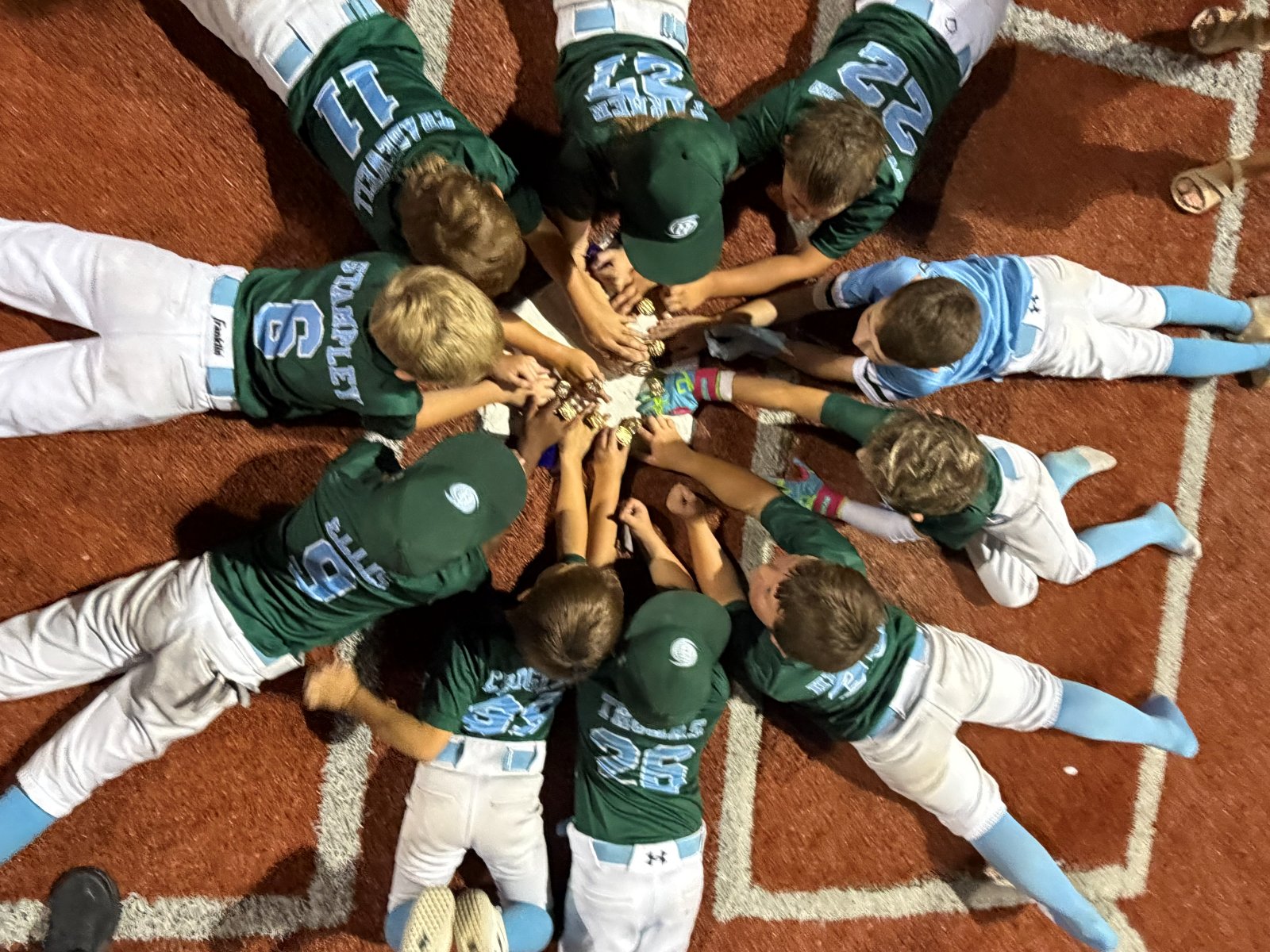 Players in a circle around home plate with their rings